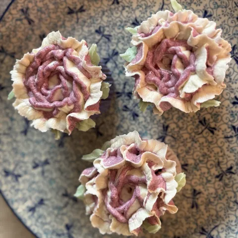 Witte chocolade Cupcake met blauwe bessen roos boven